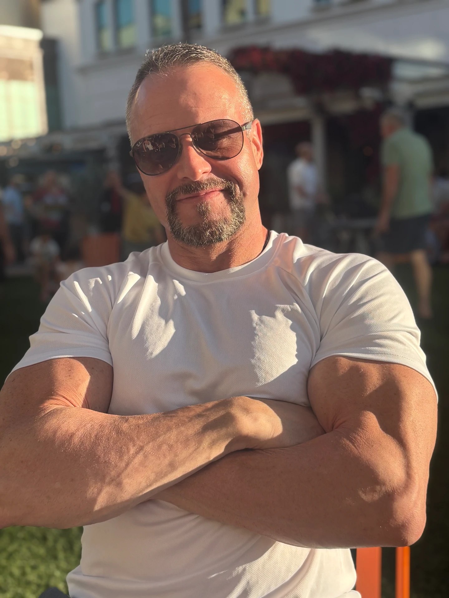 James Villepigue, founder of Faith Over Fitness™, smiling with arms crossed, wearing sunglasses and a white T-shirt